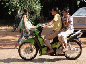Zwei Frauen auf grünem Moped